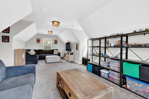 Living room featuring lofted ceiling and light carpet