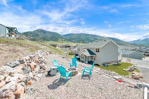 Rear view of house featuring a fire pit, a patio area, and a mountain view