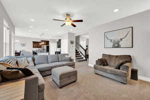 Carpeted living room featuring ceiling fan