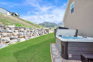 View of yard with a mountain view and a hot tub