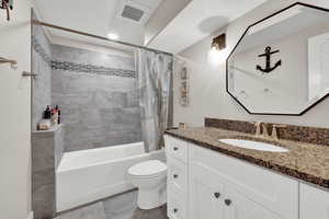 Full bathroom featuring toilet, shower / tub combo, and vanity