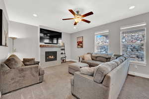 Carpeted living room with ceiling fan