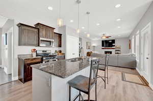 Kitchen featuring stainless steel appliances, sink, ceiling fan, and light hardwood / wood-style floors