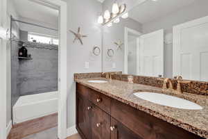 Bathroom featuring tiled shower / bath and vanity