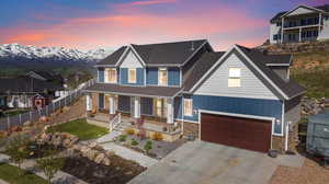 View of front of home featuring covered porch, a mountain view, and a garage