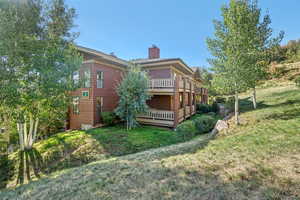 Rear view of house with a yard and a deck