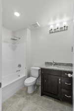 Full bathroom featuring vanity, toilet, tile patterned floors, and shower / bath combination