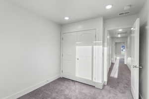 Unfurnished bedroom featuring light colored carpet and a closet