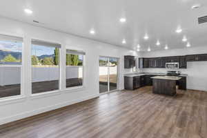 Kitchen with dark wood-type flooring, stainless steel appliances, and a center island