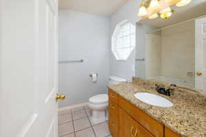 Bathroom off Primary bedroom with tile patterned floors, vanity, and toilet