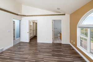 Interior space with vaulted ceiling and dark hardwood / wood-style floors