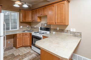 2nd Kitchen featuring kitchen peninsula, crown molding, sink, and white appliances