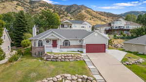 View of front of property featuring a mountain view, a front lawn, and a porch