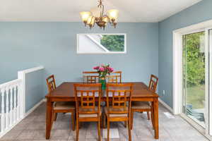 Dining area with an inviting chandelier and light tile patterned floors