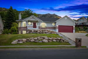 View of front facade with a garage and a yard