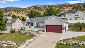 View of front facade with a mountain view, a front yard, and a porch