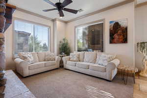 Living room featuring ceiling fan and ornamental molding