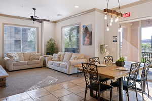 Tiled dining area featuring crown molding and ceiling fan