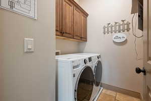 Laundry area featuring cabinets and washing machine and dryer