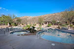 View of swimming pool with a community hot tub, a patio area, and a mountain view