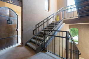 Stairs with a towering ceiling and carpet floors