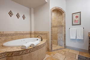 Bathroom featuring vanity and separate shower and tub