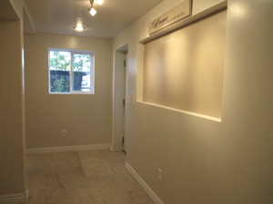 Hallway featuring light colored carpet