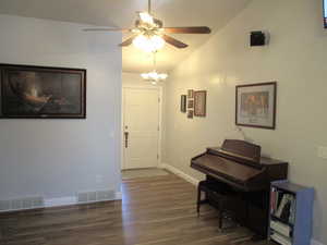 Foyer entrance featuring ceiling fan, dark hardwood / wood-style floors, and vaulted ceiling