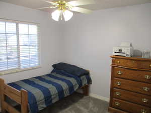 Carpeted bedroom featuring ceiling fan