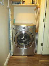 Washroom on main floor featuring dark hardwood / wood-style flooring and washer / clothes dryer