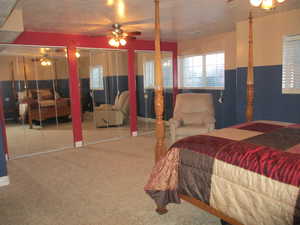 Bedroom featuring ceiling fan, carpet, and multiple closets