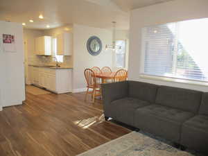 Living room featuring hardwood / wood-style flooring, an inviting chandelier, and sink