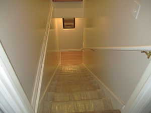 Stairs to basement with hardwood / wood-style floors