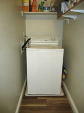 Washroom on main floor featuring dark hardwood / wood-style floors and washer / clothes dryer