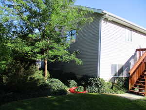 View of home's exterior with a wooden deck and a yard