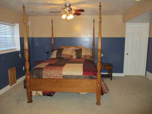 Bedroom featuring carpet flooring, ceiling fan, and a textured ceiling