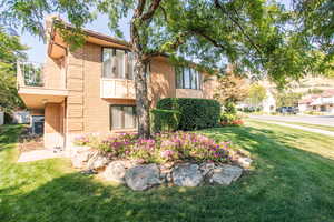 Exterior space featuring a yard, central AC unit, and a balcony