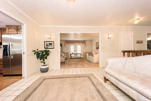 Living room with ornamental molding and light tile patterned flooring