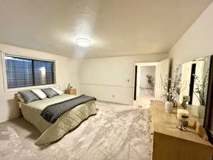 Bedroom featuring a textured ceiling and light colored carpet