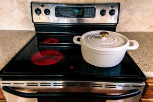 Interior details featuring stainless steel range with electric stovetop and tasteful backsplash