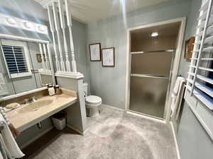 Bathroom with a shower with door, toilet, sink, and tile patterned flooring