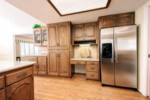 Kitchen with stainless steel fridge with ice dispenser and light hardwood / wood-style flooring