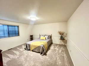 Carpeted bedroom with a textured ceiling