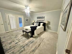 Bedroom with ornamental molding, carpet flooring, and ceiling fan