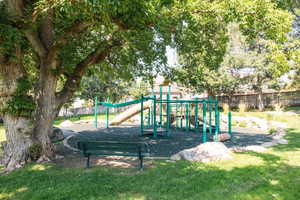 View of jungle gym with a lawn in community park.