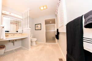 Primary bedroom bathroom featuring toilet and an enclosed shower