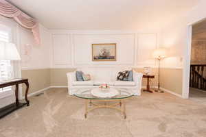 Living room with crown molding and light carpet