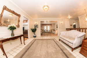 Living room featuring ornamental molding and light tile patterned flooring