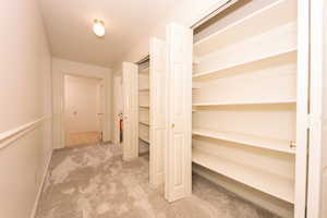 View of closets and hall leading to two storage rooms.