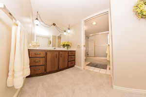 Bathroom featuring vanity, tile patterned flooring, and bath / shower combo with glass door